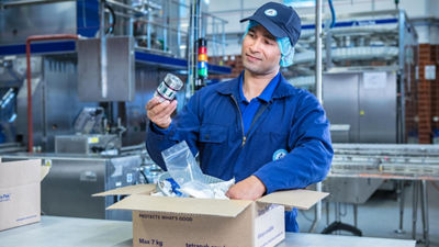 Mann hält Tetra Pak Ersatzteil in der Hand und ist glücklich